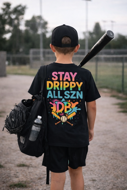 Child wearing a black t-shirt with colorful text and graphics, carrying sports equipment.